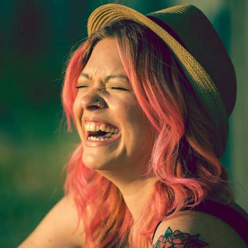 Headshot of Comedian Tracy Kellet laughing outside
