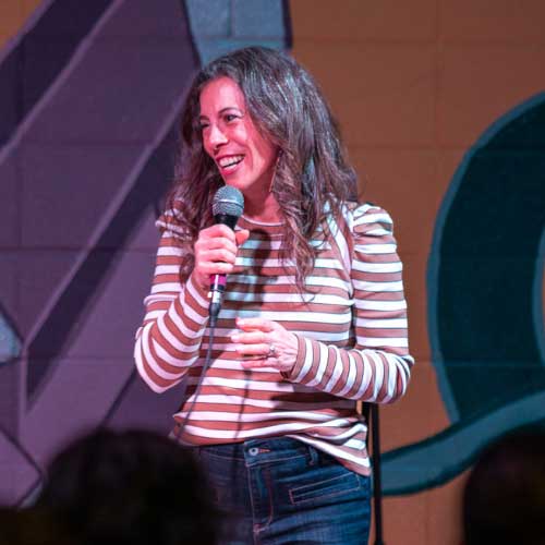 Comedian Pam Moore performing standup comedy on a stage