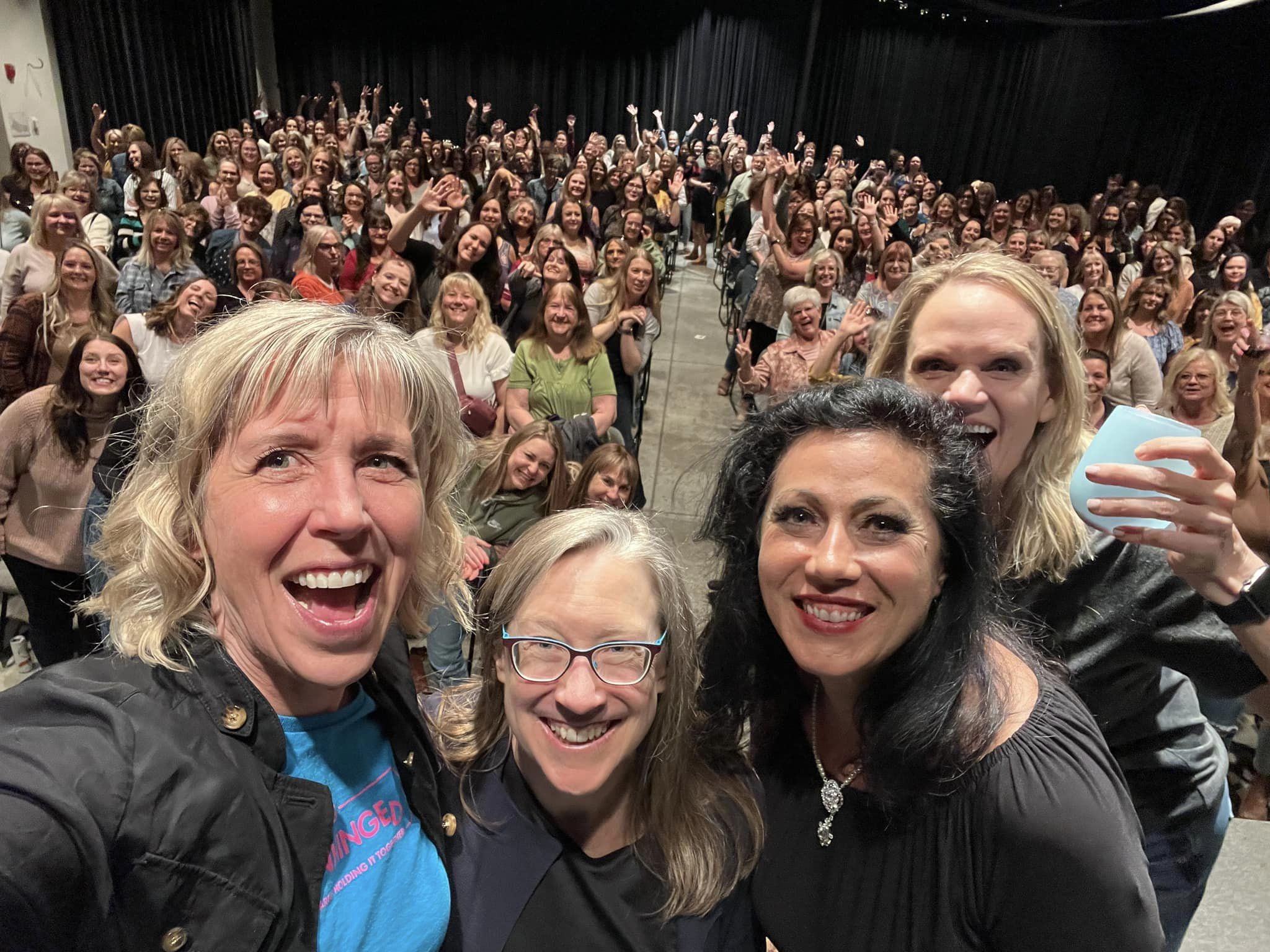 7 female comedians standing on a stage